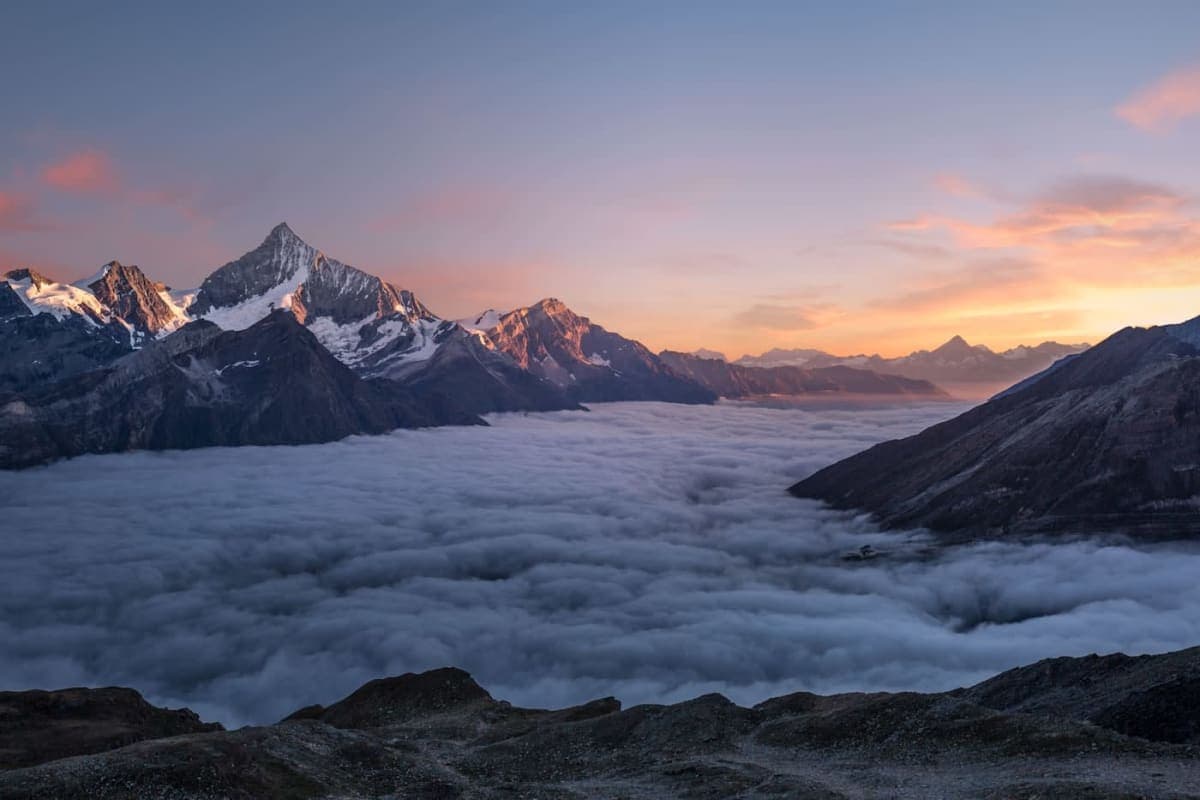 Mountain sunrise with clouds below the peaks